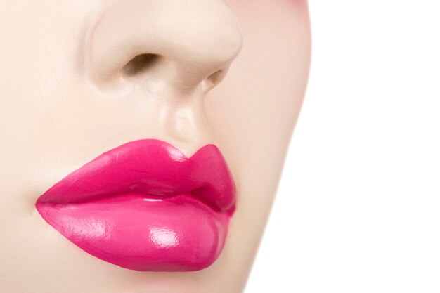 Foto close da boca e do nariz de um manequim feminino com batom rosa