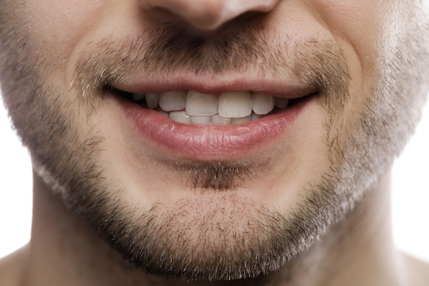 Foto close da boca masculina. sorriso saudável.