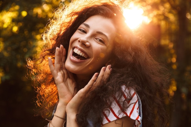 Close da foto de uma linda mulher espantada rindo de você, enquanto caminhava pelo parque em um dia ensolarado