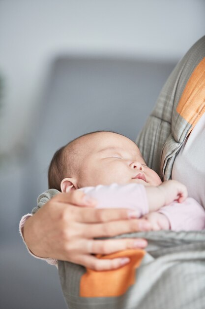 Close da mãe segurando o bebê adormecido nas mãos