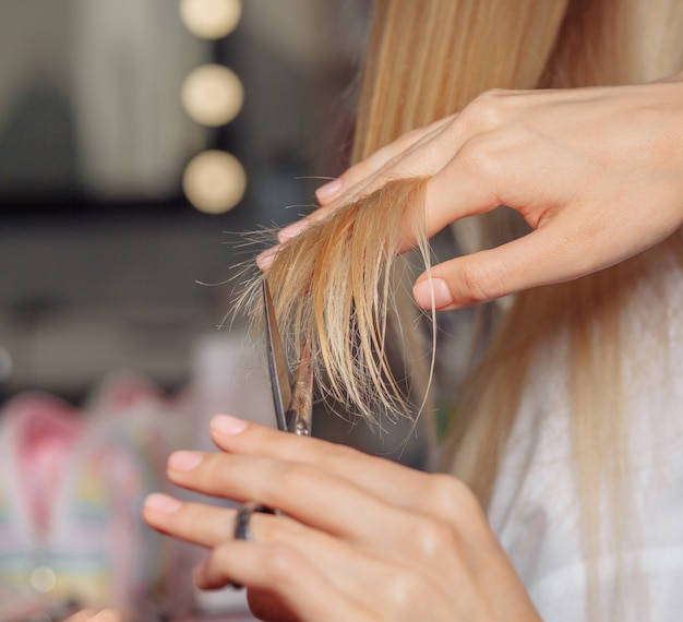 Close da mão de um cabeleireiro cortando o cabelo de uma cliente depois de morrer