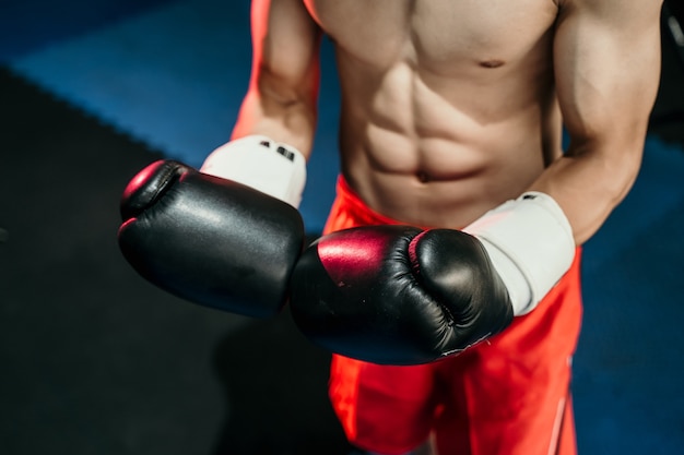 Close da mão do boxeador em luvas de boxe no ringue de boxe