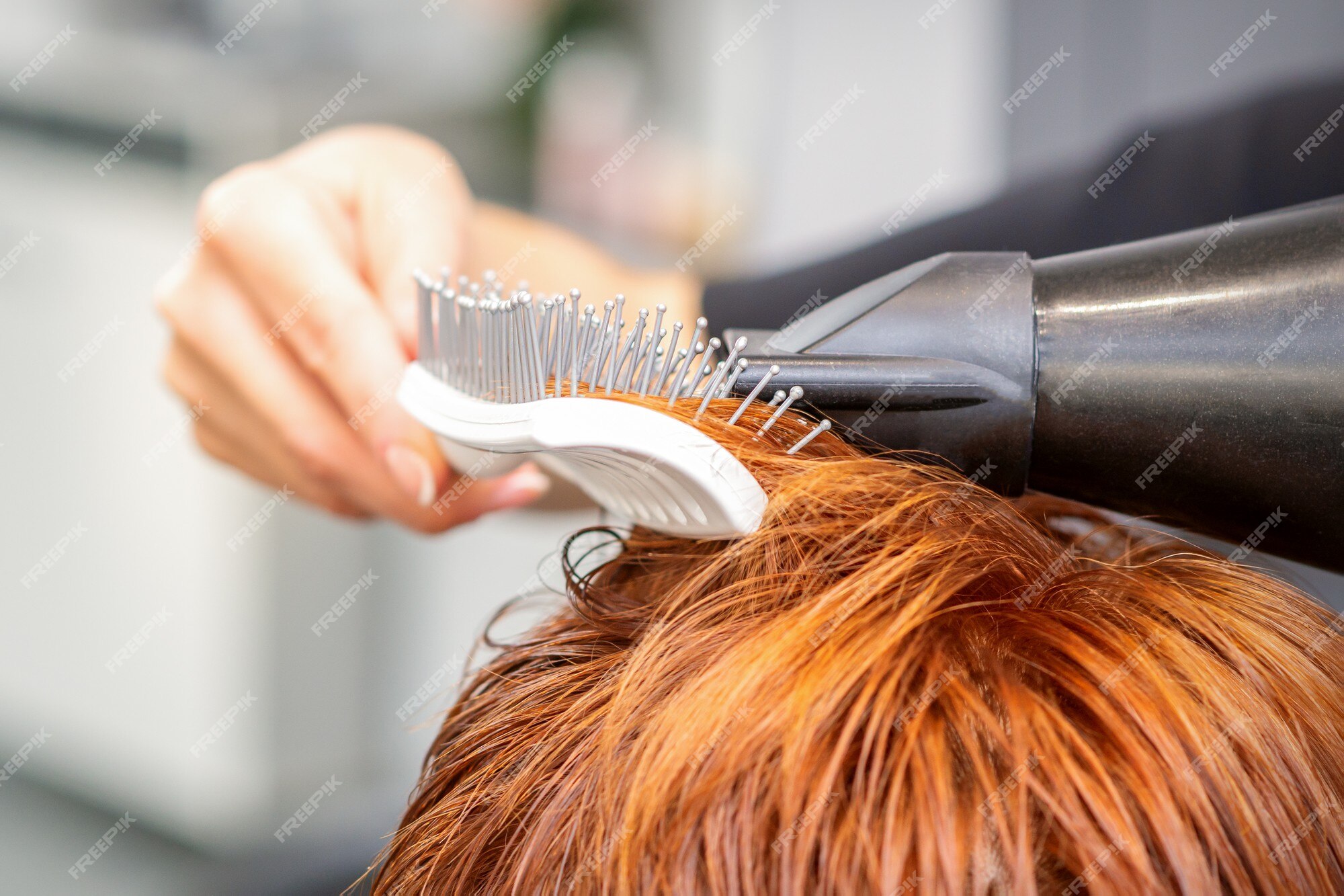 Mestre cabeleireiro faz penteado feminino com secador de cabelo e produtos  para o cabelo