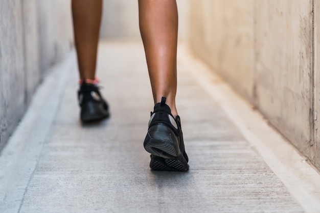 Close da mulher atleta correndo e fazendo exercícios ao ar livre