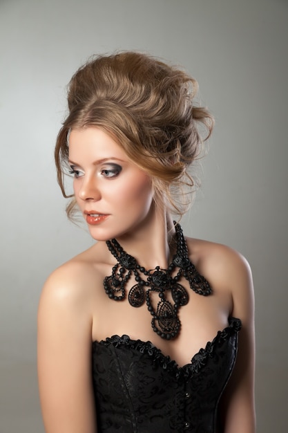 Foto close da mulher bonita com maquiagem de noite e grande colar preto. joias e beleza. foto de moda