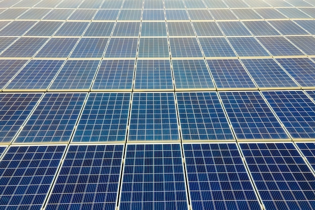 Foto close da superfície dos painéis solares fotovoltaicos azuis montados no telhado do prédio para a produção de eletricidade ecológica limpa. produção do conceito de energia renovável.