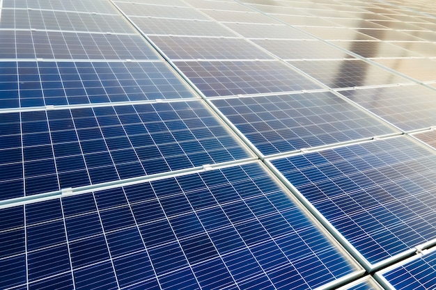 Close da superfície dos painéis solares fotovoltaicos azuis montados no telhado do prédio para a produção de eletricidade ecológica limpa. produção do conceito de energia renovável.