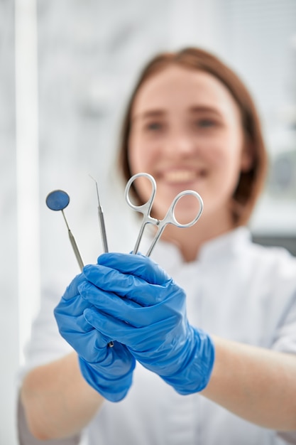 Close das mãos e equipamentos odontológicos do dentista