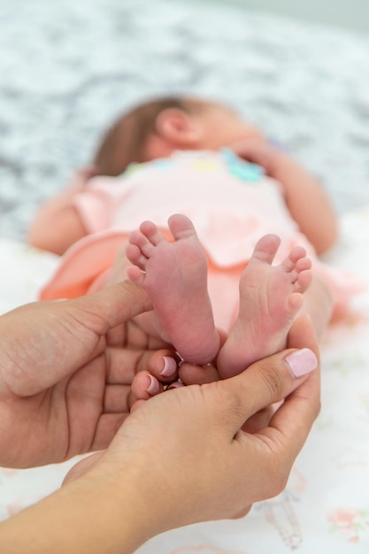 Close das perninhas de um bebê recém-nascido nas mãos de uma mulher ou mãe Momentos com uma criança