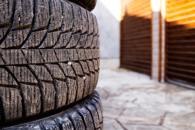 Close das ranhuras em pedras de pneu de carro presas dentro das rodas de inverno de foco seletivo de borracha após o uso