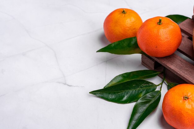 Close das tangerinas frescas e deliciosas em uma superfície branca