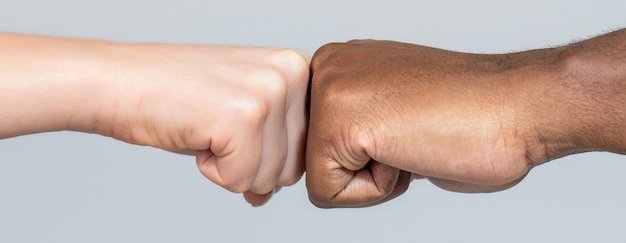 Foto close de amigos multiculturais dando um soco no outro. mãos de homem e mulher de raça negra afro-americana dando um soco, diversidade multirracial, conceito de imigração