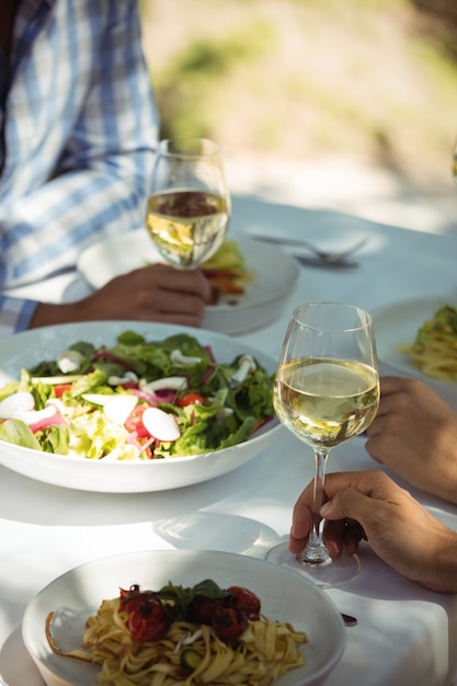 Close de comida e taça de vinho na mesa de jantar