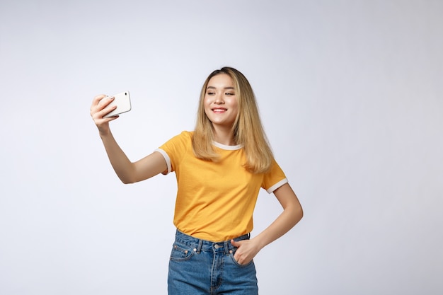 Close de jovem asiática tomando uma selfie