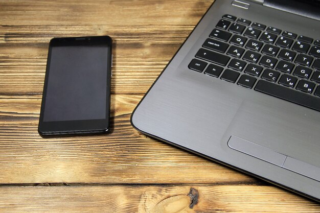 Close de laptop e smartphone na mesa de madeira