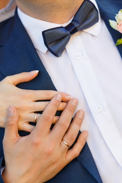 Close de mãos com anéis na cerimônia de casamento