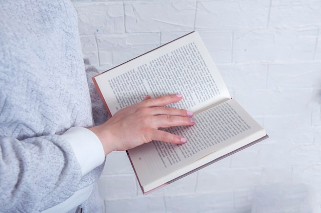 Close de mãos de mulheres segurando um livro