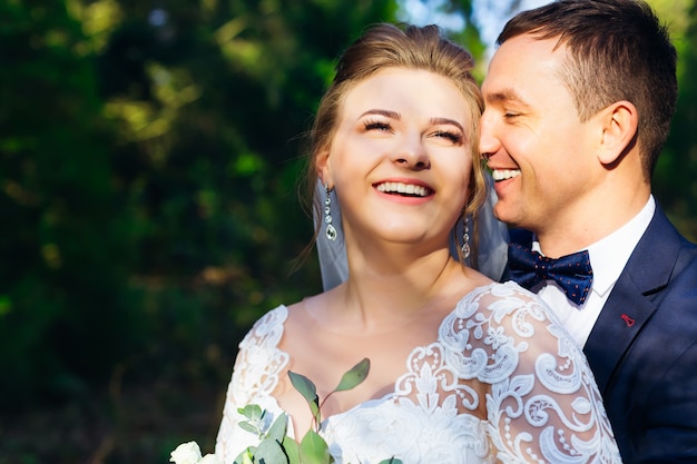 Close de recém-casados felizes nos braços um do outro e sorrisos doces