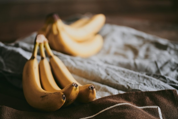 Foto close de um cacho de bananas em um fundo de tecido escuro