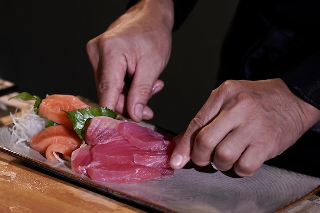 Close de um chef japonês se preparando para cozinhar comida japonesa faça sushi em um restaurante tradicional japonês em uma tábua de cortar