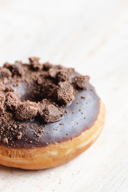 Close de um donut de chocolate com cobertura de pedaços de chocolate