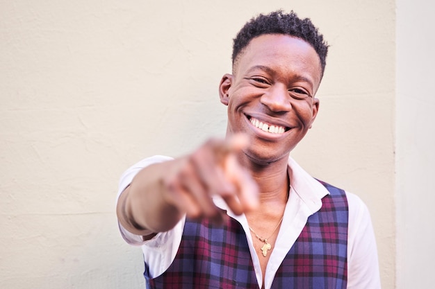 Foto close de um homem afro-americano estiloso rindo alto apontando para a câmera