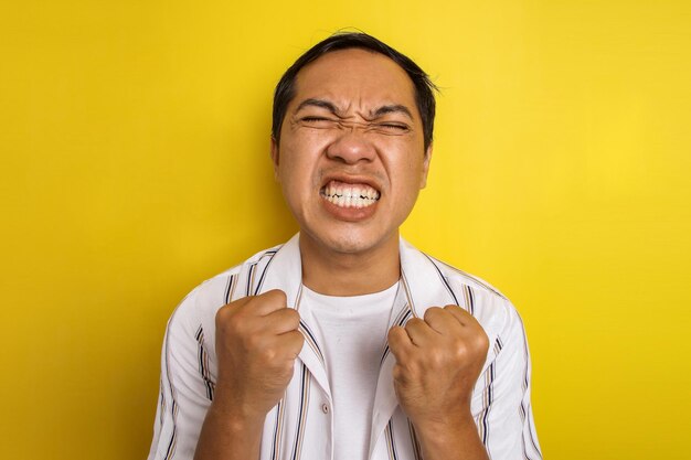 Close de um homem asiático muito feliz e animado fazendo o gesto e a expressão do vencedor