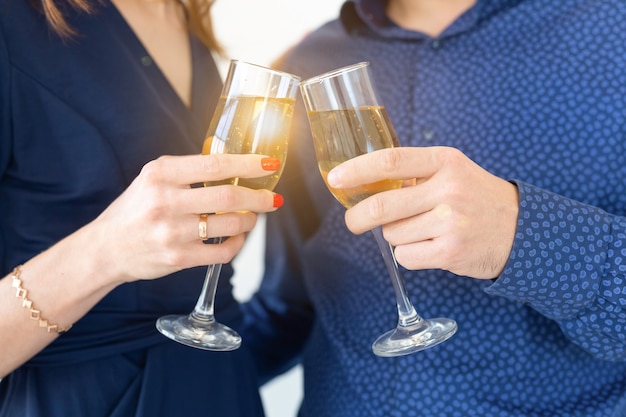 Close de um homem e uma mulher comemorando a festa de Natal ou Ano Novo com luzes de Bengala e taças de champanhe