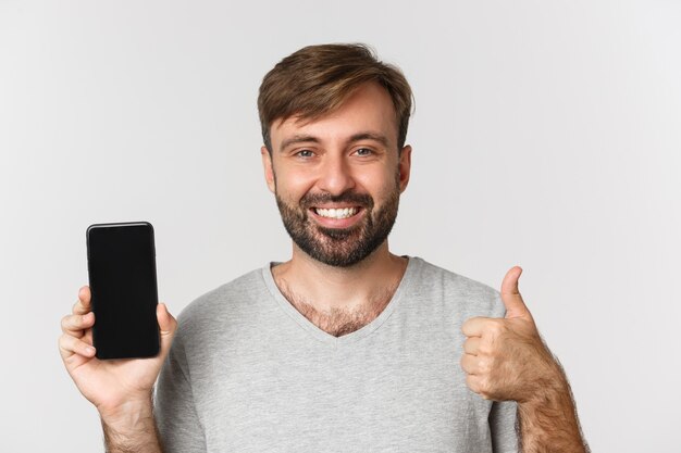 Close de um homem sorridente bonito em uma camiseta cinza