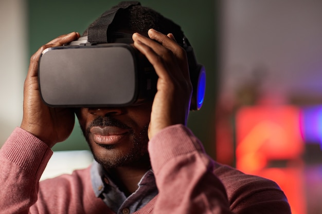 Close de um jovem africano de óculos durante um jogo de realidade virtual