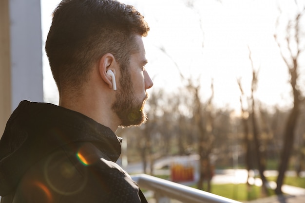 Close de um jovem esportista focado em fones de ouvido