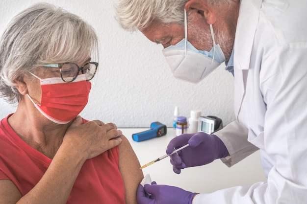 Close de um médico vacinando um paciente idoso. conceito de vacinação contra o coronavírus covid-19