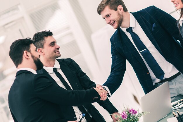 Close de um parceiro de negócios de aperto de mão de sucesso após a assinatura do contrato no local de trabalho em um escritório moderno