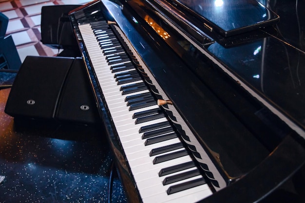 Close de um piano preto em um restaurante com teclas de piano preto e branco