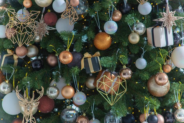 Close de uma árvore de Natal decorada de maneira festiva com bolas e presentes