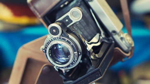 Close de uma câmera fotográfica de filme vintage retrô com lente em um estojo de couro