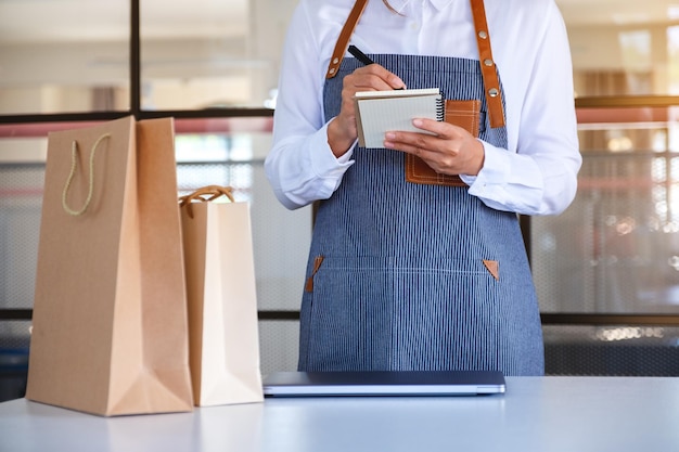 Close de uma empresária ou garçonete verificando pedidos do cliente