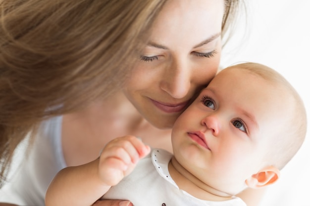 Close de uma mãe sorridente e bebê