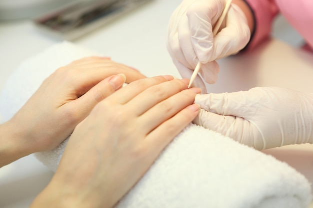 Close de uma mulher em um salão de manicure fazendo as unhas