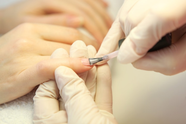 Close de uma mulher em um salão de manicure fazendo as unhas