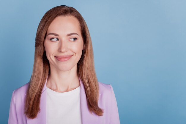 Close de uma mulher sorrindo; olhe para o espaço vazio do lado da parede azul