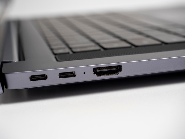 Close de uma parte de um laptop sobre um fundo claro Grandes portas USB tipo S e HDMI no laptop Foco seletivo do teclado do laptop aberto