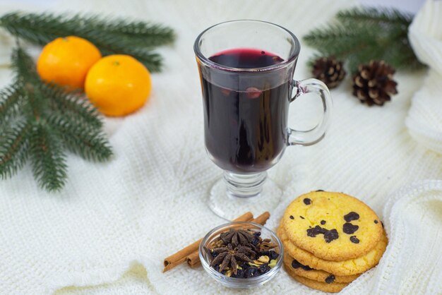 Close de vinho quente com tangerinas e biscoitos em um interior aconchegante de Natal