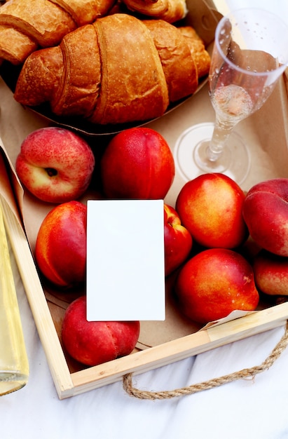 Close do cartão em branco ou nota. Croissant, limonada e frutas de pêssego