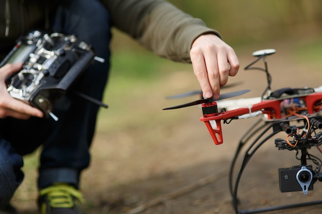 Close do drone da hélice consertando a mão do homem