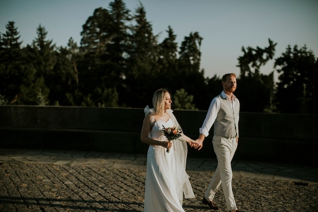Close do lindo casal jovem recém-casado caminhando no parque