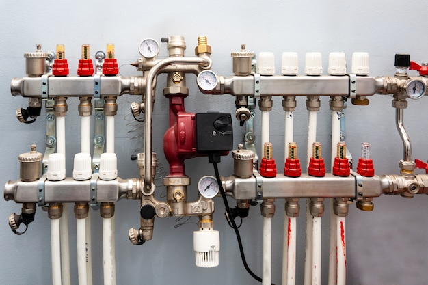 Close do manômetro, tubos e válvulas de torneira do sistema de aquecimento em uma sala de caldeira