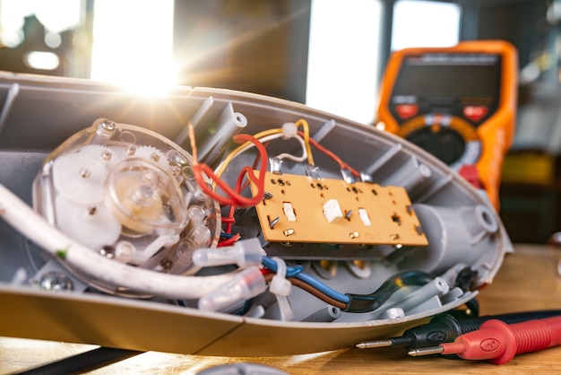 Foto close do motor de ferro de um ventilador doméstico repousa sobre uma mesa em conserto