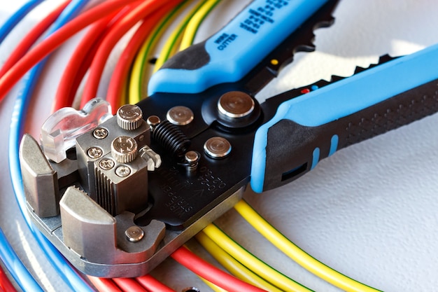 Foto close do removedor e cortador de fios com cabos de alimentação coloridos