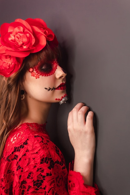 Foto close dos detalhes do perfil de uma garota com maquiagem dia de los muertos.